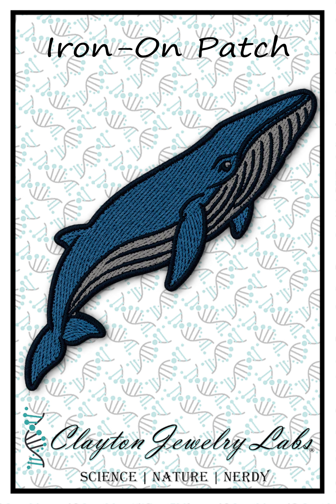 An embroidered whale-shaped iron-on patch with a blue body, gray underbelly, and black outline, shown on a white patterned background with the text 'Iron-On Patch' and 'Clayton Jewelry Labs'.
