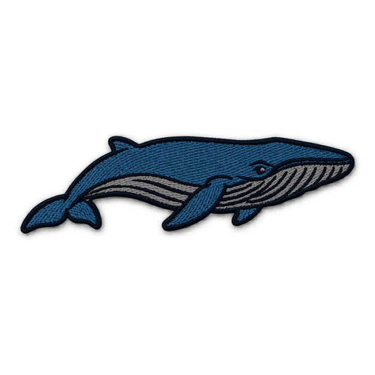 An embroidered blue whale patch in shades of blue and gray with a black stitched border, shown on a plain white background.