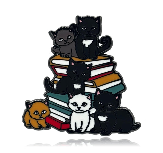 Enamel pin with cartoon cats on books against a white background