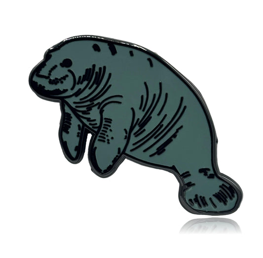 Manatee-shaped enamel pin on a white background