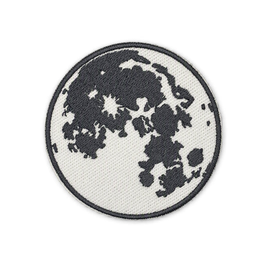 A circular embroidered patch depicting the moon with dark gray craters on a white background, finished with a dark gray stitched border, shown on a plain white background.