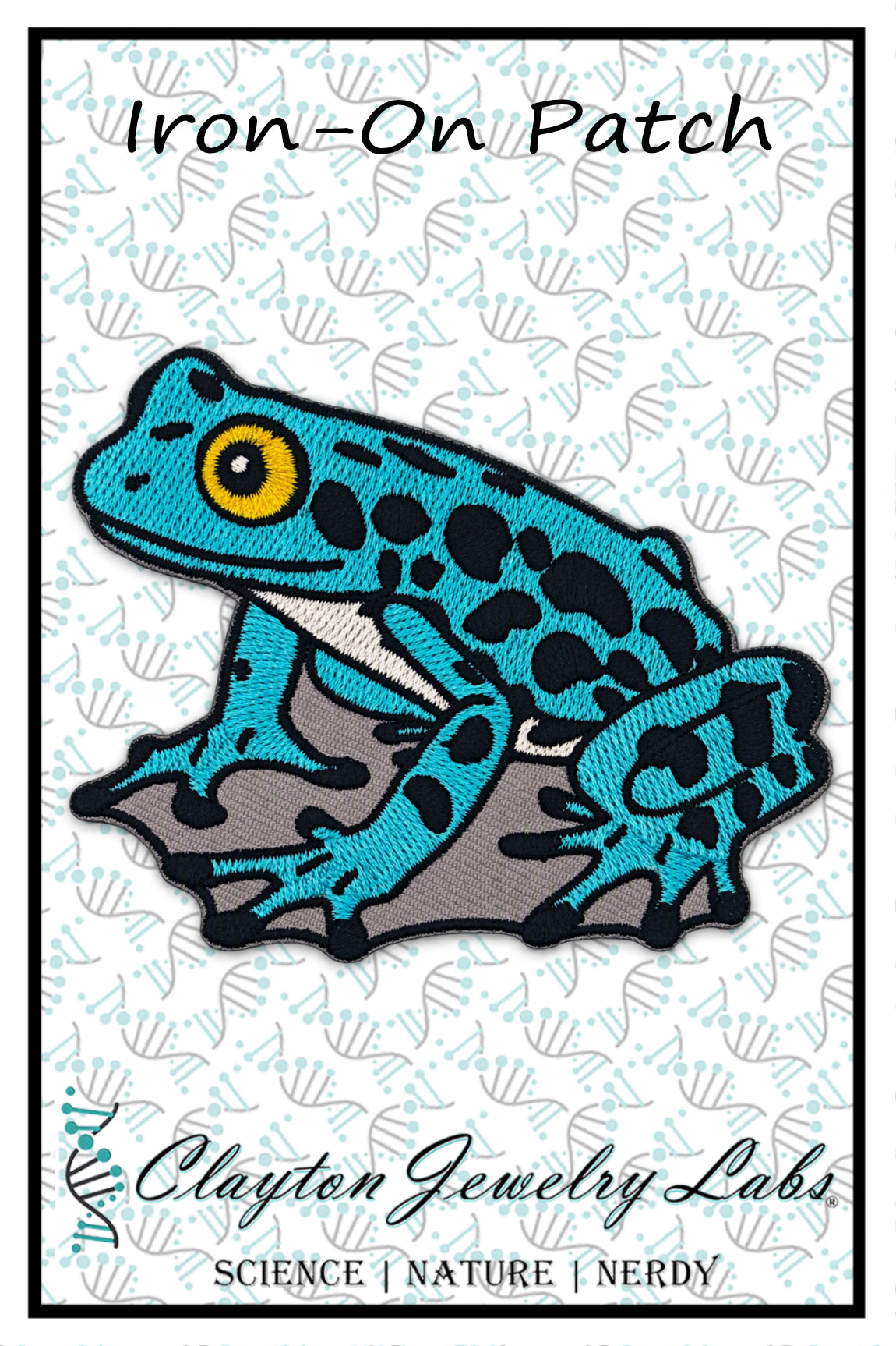 An embroidered iron-on patch of a blue and black spotted frog sitting on a gray rock, displayed on a white patterned card with the text 'Iron-On Patch' and 'Clayton Jewelry Labs'.