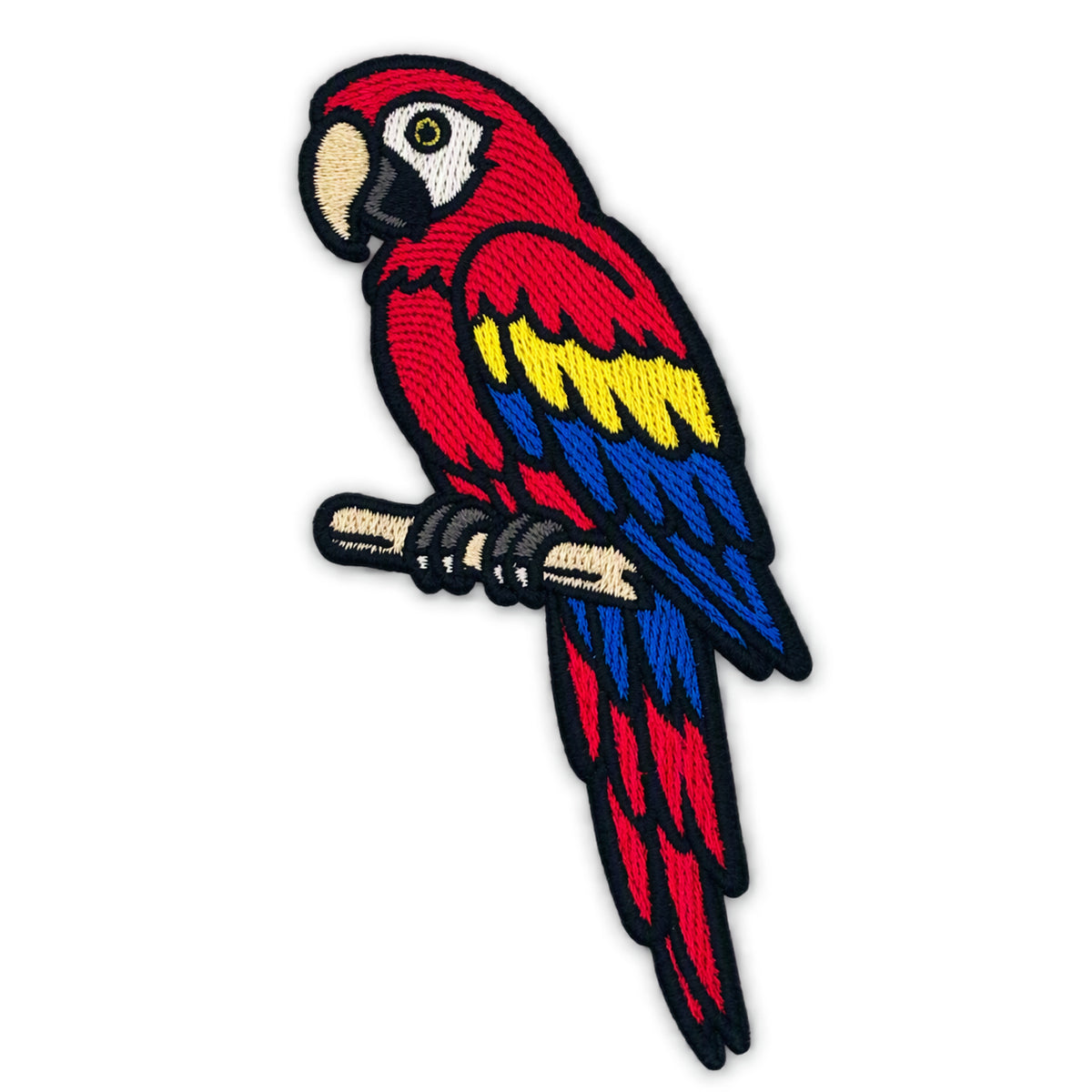 An embroidered iron-on patch of a red, yellow, and blue parrot perched on a branch, shown against a plain white background.